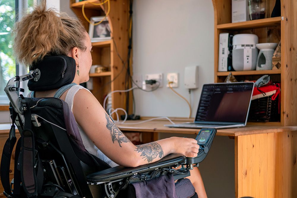 Web Accessibility - Woman in an electric wheelchair looking at her laptop
